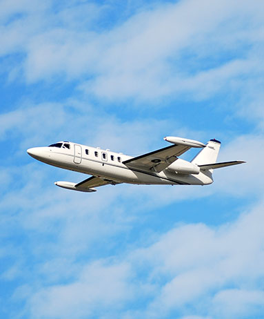 small private jet flying in blue sky