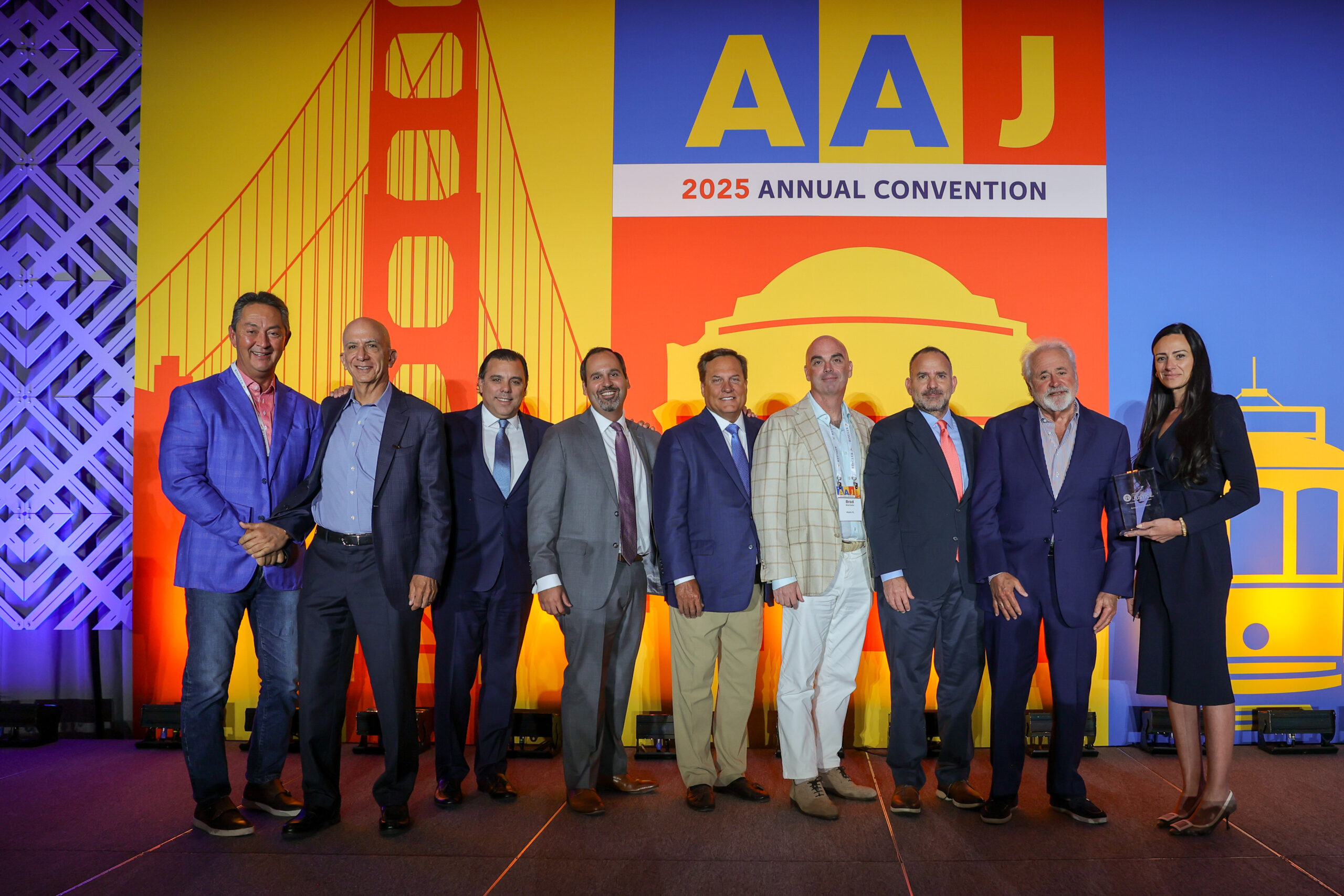 Group of lawyers in front of a sign at the American Association for Justice Annual Convention