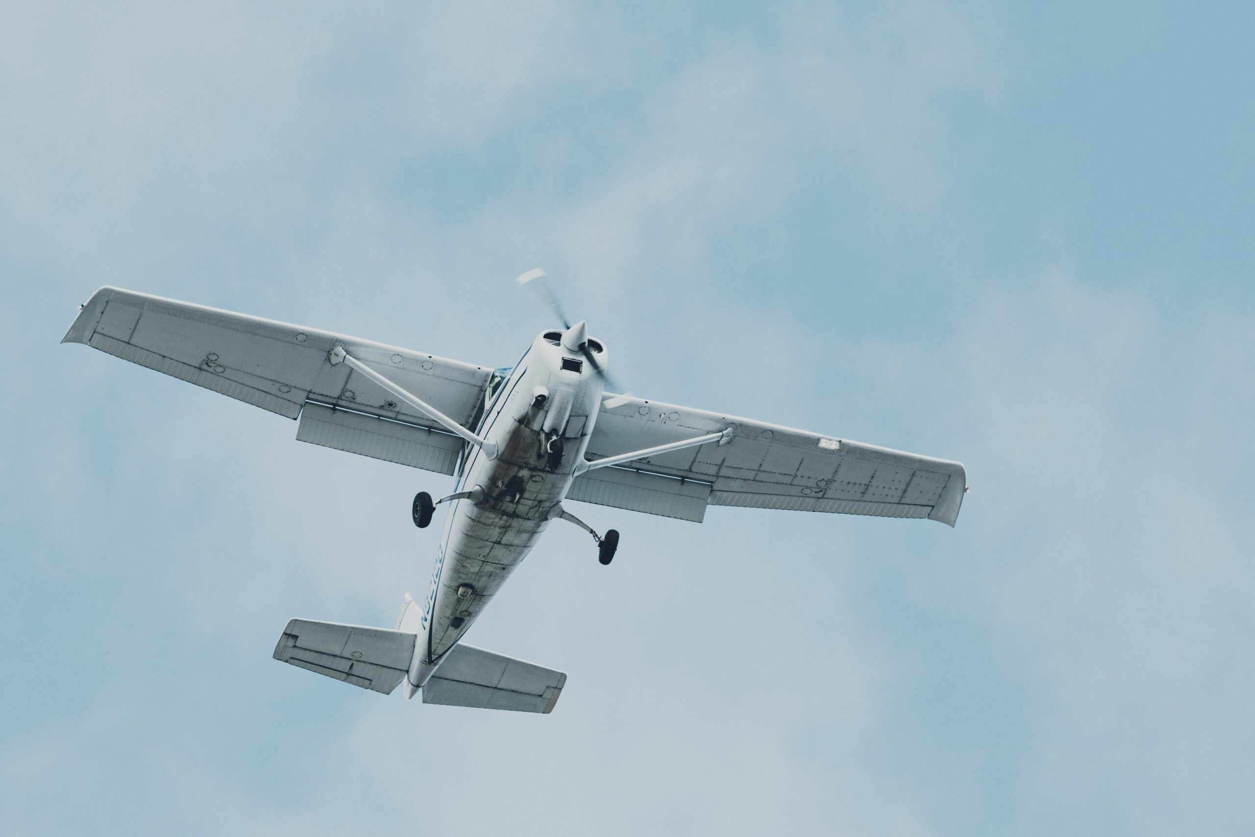 Small white airplane flying in the sky