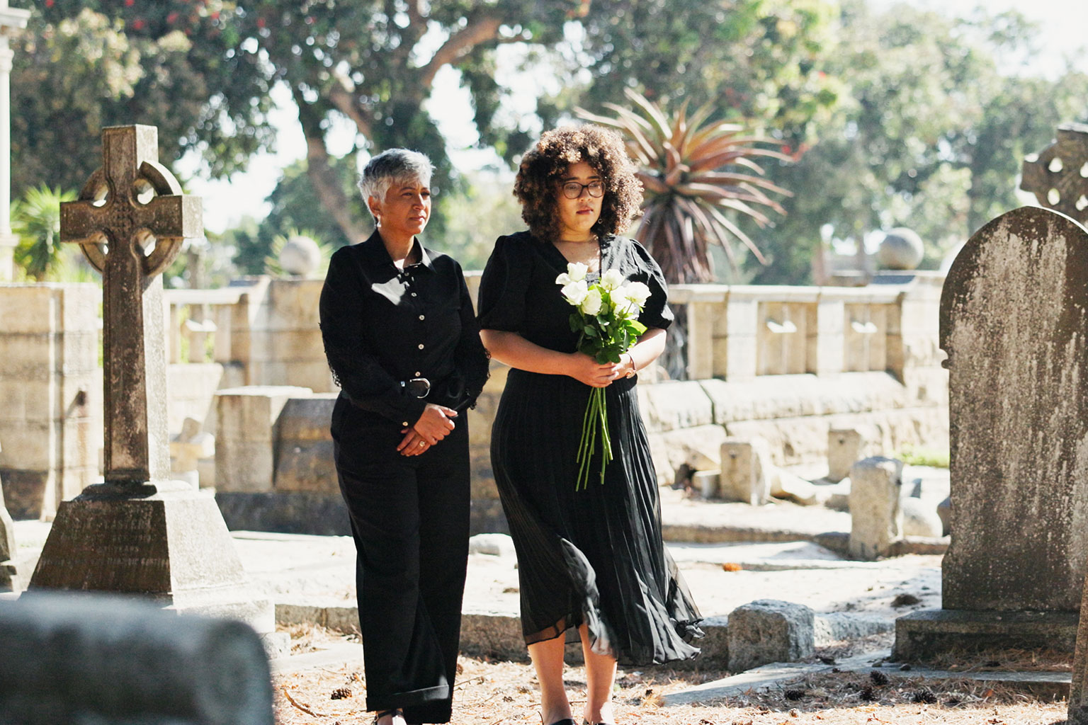 grieving family walking through cemetary